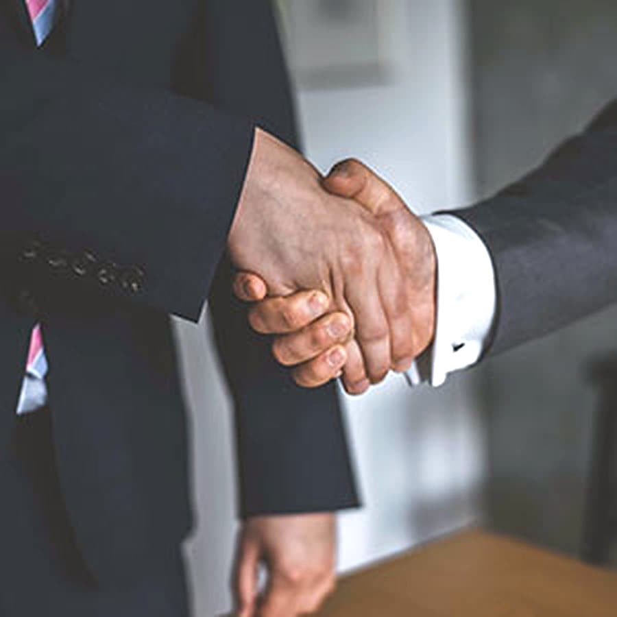 Two men in suits shaking hands after a meeting
